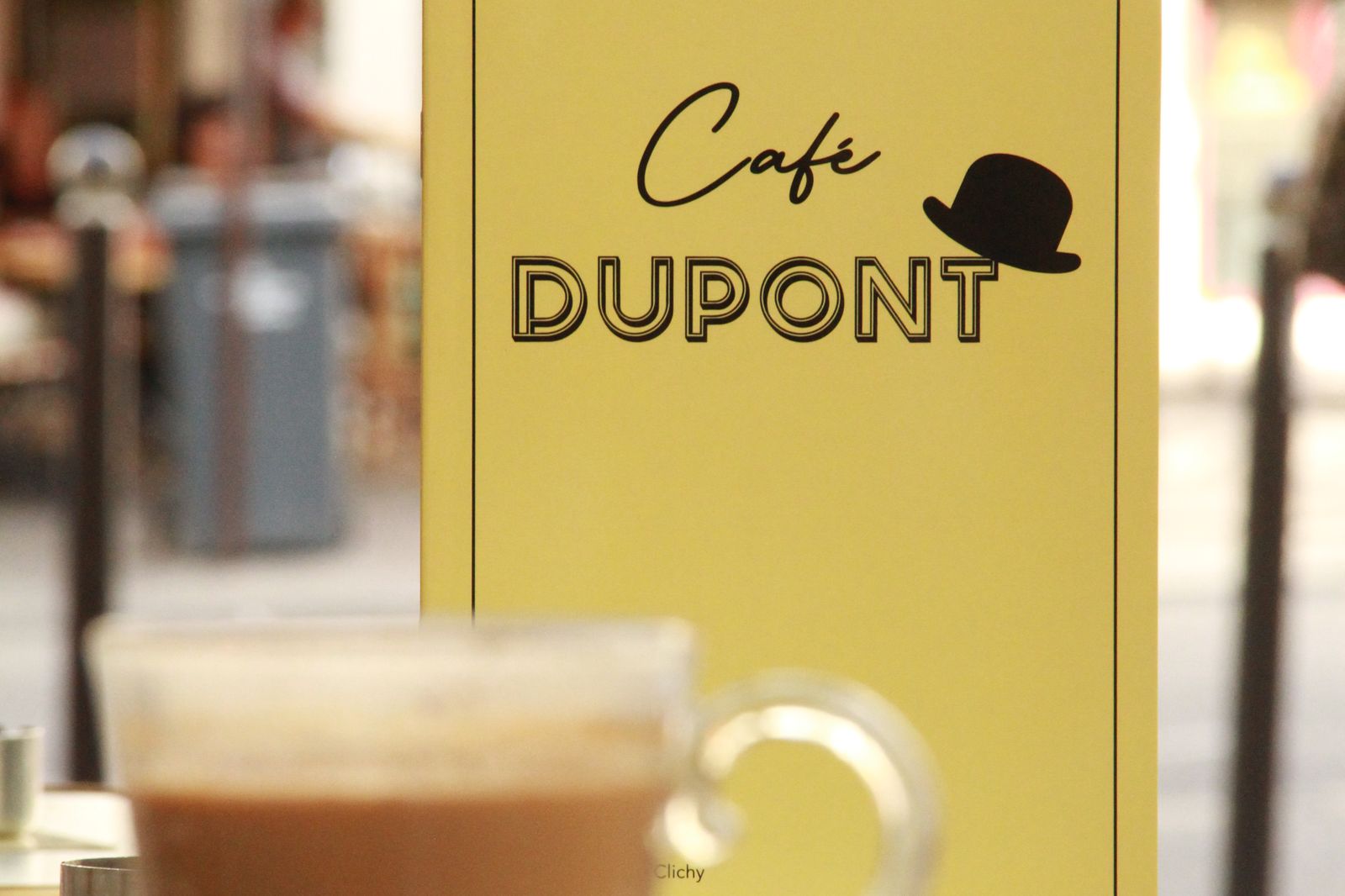 Un café devant l’enseigne du Café Dupont
