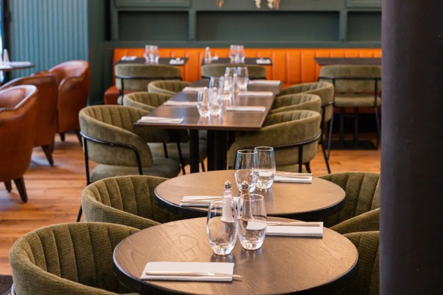 La salle du Bistrot Jad, vitrines fleuries et banquette orange