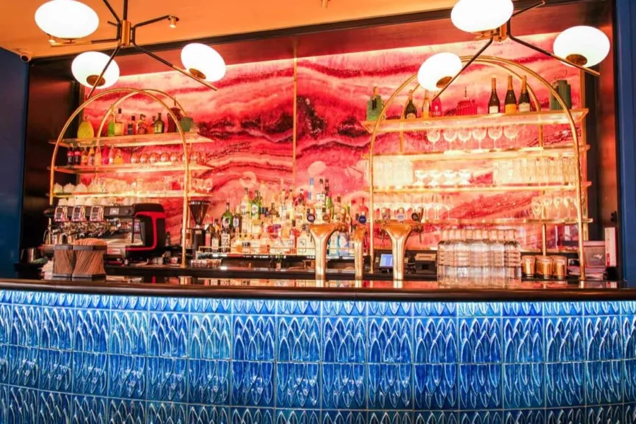 Le bar des Pipelettes du Boulevard, comptoir de faïence bleue et fresque de marbre rose